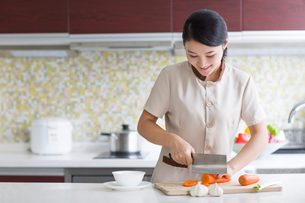 Domestic staff cooking in kitchen